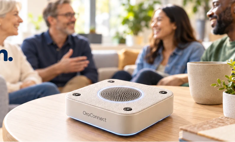 A group sharing a conversation around an OroConnect tabletop audio device